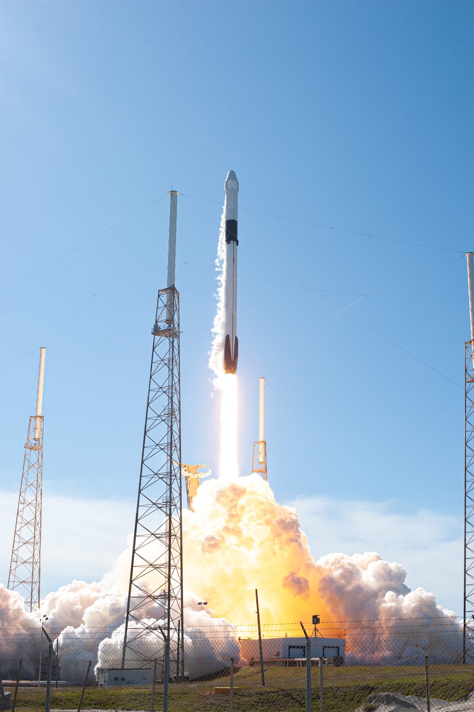 A Falcon 9 rocket lifting off in daylight